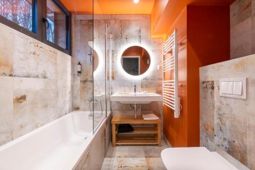 a bathroom with a tub and a sink and a shower at Hotel Le Bois Joli in Bernex