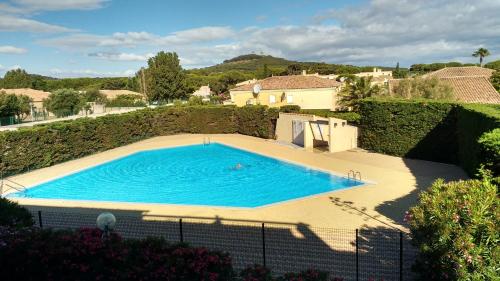 une grande piscine bleue dans une cour dans l'établissement Cap d'Agde Naturiste côté PORT, au Cap d'Agde
