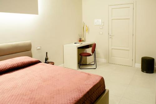 a bedroom with a bed and a desk and a chair at Amnis rooms in Salerno