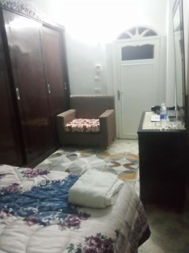a bedroom with a bed and a dresser and a chair at Nubian Life Nile View in Aswan