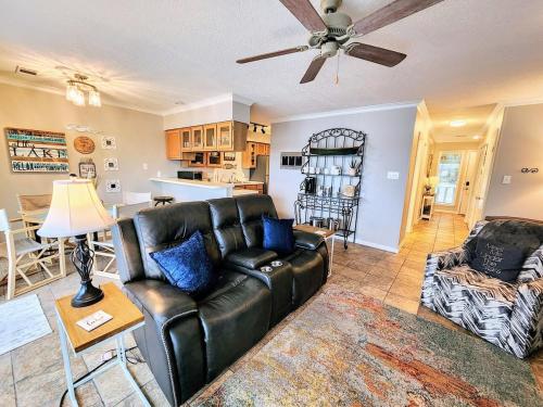 a living room with a leather couch and a table at Farr Shores Cozy Retreat in Red Oak