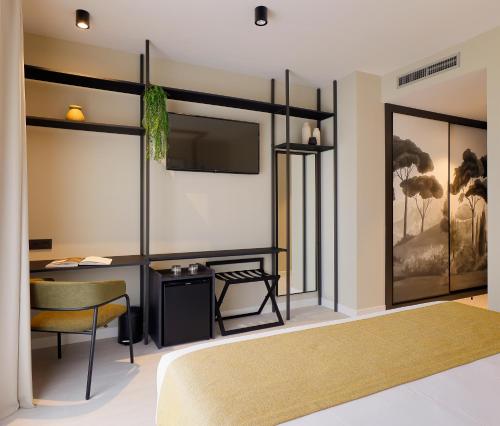 a bedroom with a bed and a desk and a tv at Nuvō Hotel Boutique in Oviedo