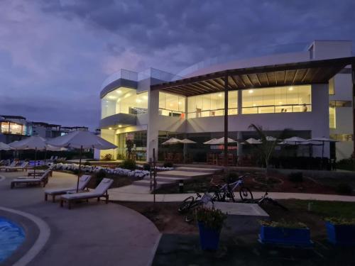 a large building with benches and umbrellas in front of it at Departamento de Playa (con piscina propia) en km 107 Asia, Lima in Asia