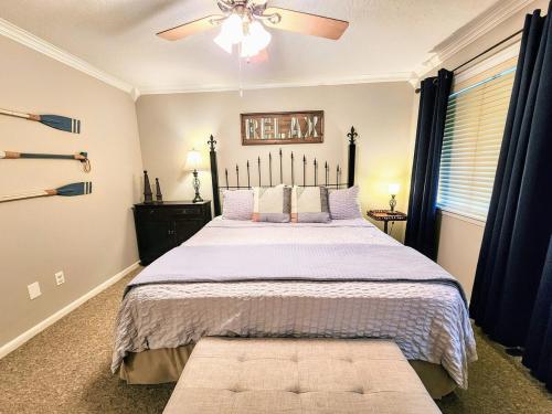 Un dormitorio con una cama grande con ventilador de techo. en Farr Shores Cozy Retreat, en Red Oak