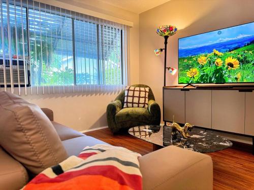a living room with a couch and a flat screen tv at Fire Support 3Bedroom Modern Luxury House in Central Pasadena in Pasadena