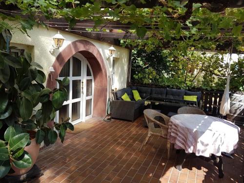 an outdoor patio with a table and a couch at Großes Glück in Gleisweiler