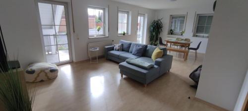 a living room with a blue couch and a table at Ferienwohnungen "Weingenuss" für 1 bis zu 10 Personen direkt im Weingut in Sulzfeld am Main