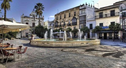 una fuente en medio de un patio con edificios en Apartamento Al Sur del Sur, en Sanlúcar de Barrameda