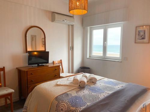 a bedroom with a bed and a television and a window at Apartamento T1, Praia da Rocha - Edificio Mar Azul in Portimão