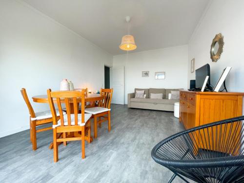 a dining room and living room with a table and chairs at Apartamento T1, Praia da Rocha - Edificio Mar Azul in Portimão