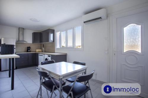 une cuisine avec une table et des chaises dans une pièce dans l'établissement Apartment T3 air-conditioned on one level on the heights of Nice, à Nice