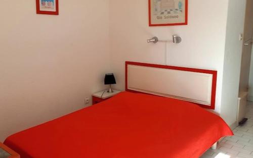 - une chambre avec un lit rouge et un grand miroir dans l'établissement Cap d'Agde Naturiste côté PORT, au Cap d'Agde