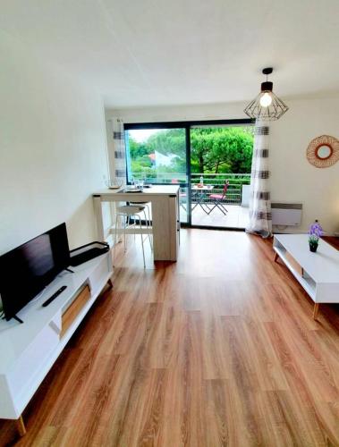 Il comprend un salon doté de parquet et d'une grande fenêtre. dans l'établissement La Frégate studio spacieux avec terrasse, à La Rochelle