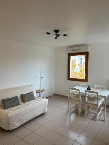 un salon avec un canapé blanc et une table dans l'établissement Appartement cosy proche de Paris avec Parking privé, à Vitry-sur-Seine