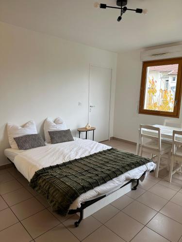 - une chambre avec un lit, une table et des chaises dans l'établissement Appartement cosy proche de Paris avec Parking privé, à Vitry-sur-Seine