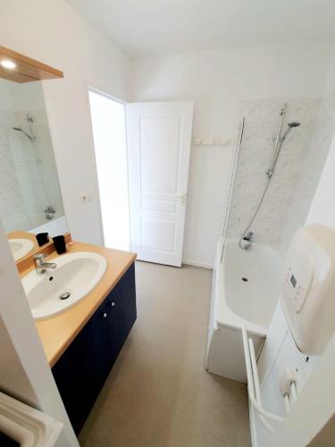 une salle de bain blanche avec un lavabo et une douche dans l'établissement La Frégate studio spacieux avec terrasse, à La Rochelle
