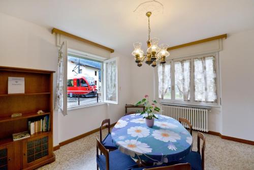 a dining room with a table and a red truck in the window at Miralago Apartments - 8 min Walk to Bernina Express in Tirano