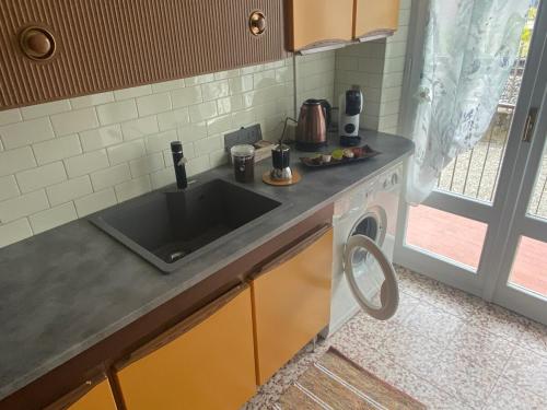 a kitchen with a sink and a washing machine at Miralago Apartments - 8 min Walk to Bernina Express in Tirano