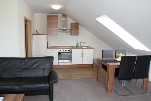 a living room with a table and a kitchen at Landhotel Möllhagen in Schülp