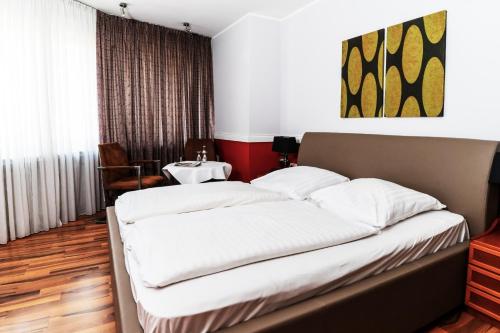 a large bed in a room with a table at Privathotel Stickdorn in Bad Oeynhausen