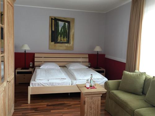a bedroom with a bed and a couch at Privathotel Stickdorn in Bad Oeynhausen