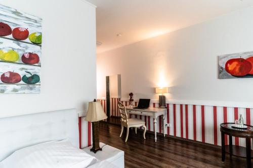 a bedroom with a bed and a desk with a laptop at Privathotel Stickdorn in Bad Oeynhausen