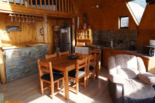 a kitchen with a table and chairs in a cabin at Domos Curiñanco vista al mar in Valdivia