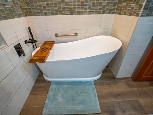 a white bath tub sitting in a bathroom at Maya Beach Hotel in Maya Beach