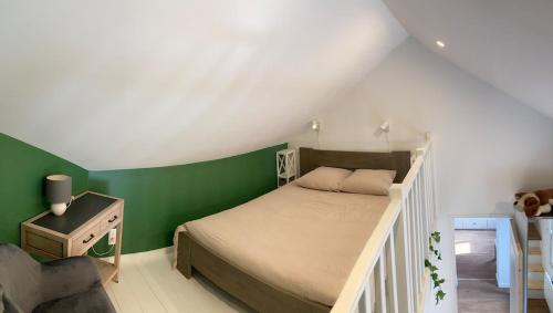a bedroom with a bed and a green wall at Maisonnette Individuelle in Carpiquet