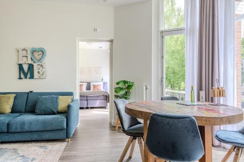 a living room with a table and a blue couch at Hotel Oranjestaete in Nijmegen