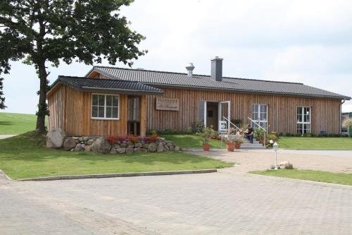 una pequeña casa de madera con un árbol delante en Landhotel Möllhagen, en Schülp