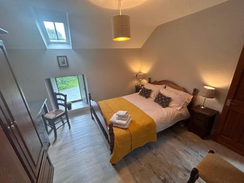 a bedroom with a bed and a chair and a window at Aldernaig Mill in Invergarry