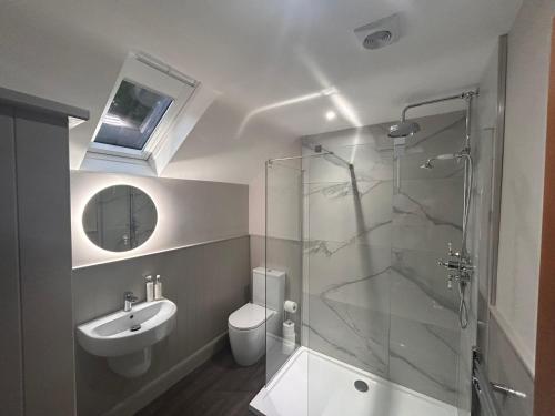 a bathroom with a shower and a sink and a toilet at Aldernaig Mill in Invergarry