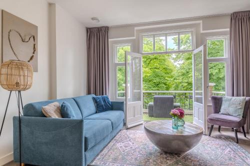 a living room with a blue couch and a table at Hotel Oranjestaete in Nijmegen