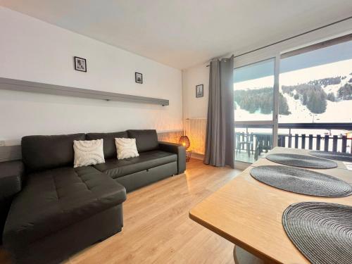 un salon avec un canapé et une table dans l'établissement Sot'O'Ski - Pied des pistes, 4 personnes, Centre station, Bois d' Aurouze, à Saint-Étienne-en-Dévoluy