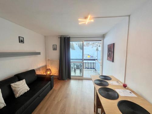 un salon avec un canapé noir et une table dans l'établissement Sot'O'Ski - Pied des pistes, 4 personnes, Centre station, Bois d' Aurouze, à Saint-Étienne-en-Dévoluy