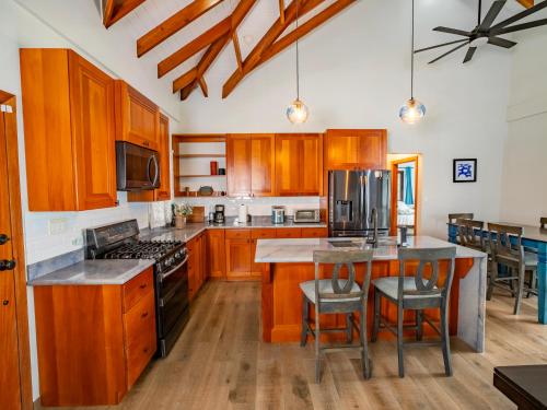 a kitchen with wooden cabinets and a island with a stove at Maya Beach Hotel in Maya Beach