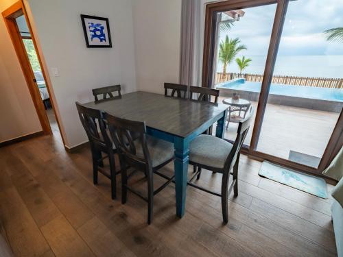 a dining room table and chairs with a view of the ocean at Maya Beach Hotel in Maya Beach