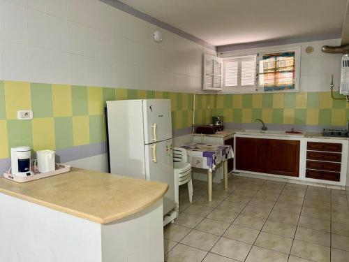a kitchen with a refrigerator and a table in it at Family-Friendly Studio in Mahdia
