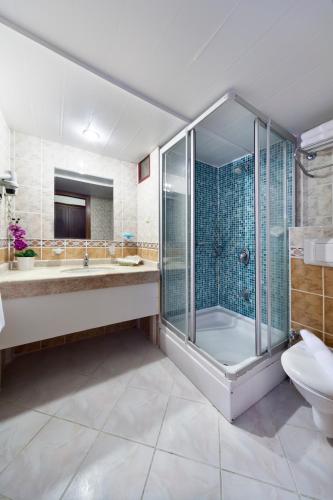 a bathroom with a shower and a sink and a toilet at Crystal Hotel Bodrum in Gumusluk