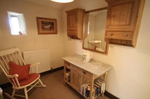 a room with a table and a chair and a mirror at Riding house Farm Cottages in Castleton
