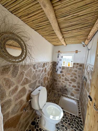 a bathroom with a toilet and a stone wall at Fisherman House in Wassane