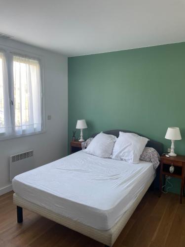 une chambre avec un lit avec des draps blancs et des oreillers dans l'établissement Maison Vivaldi pour 6 pers Andernos les Bains, à Andernos-les-Bains