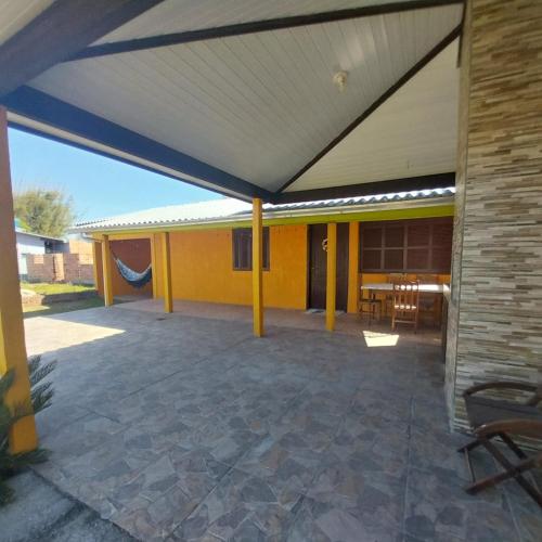 an outdoor patio with awning on a house at Paraíso em torres in Torres