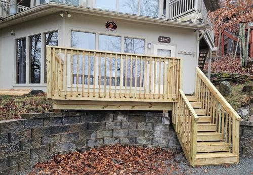 a house with a wooden staircase in front of it at Slopesider 23C condo in Sugar Mountain