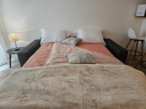 un grand lit avec deux oreillers dessus dans l'établissement T1 - métro B François verdier, à Toulouse