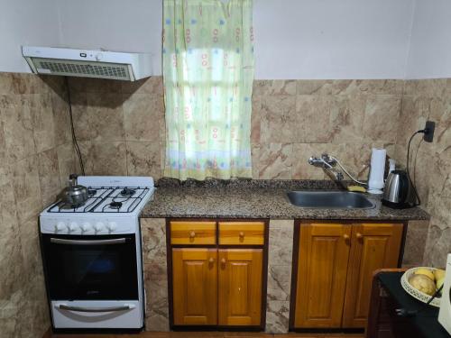 a kitchen with a stove and a sink at Lo de Toty 1 in Yapeyú