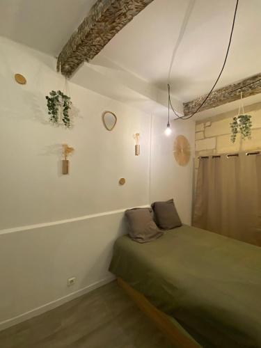 une chambre avec un lit dans le coin d'une pièce dans l'établissement Location studio rue du sauvage, à Arles