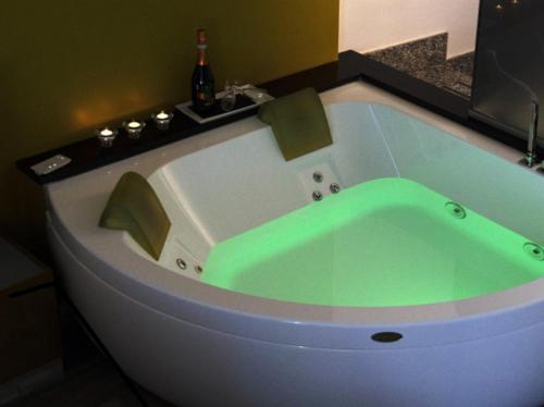 La salle de bains est pourvue d'une baignoire verte et d'un lavabo. dans l'établissement Le Stanze di Elisa, à Rome