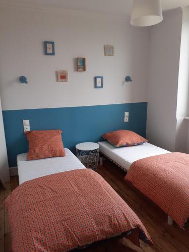 - deux lits dans une chambre bleue et rouge dans l'établissement Côte de Granit Rose 300m des plages, à Trégastel